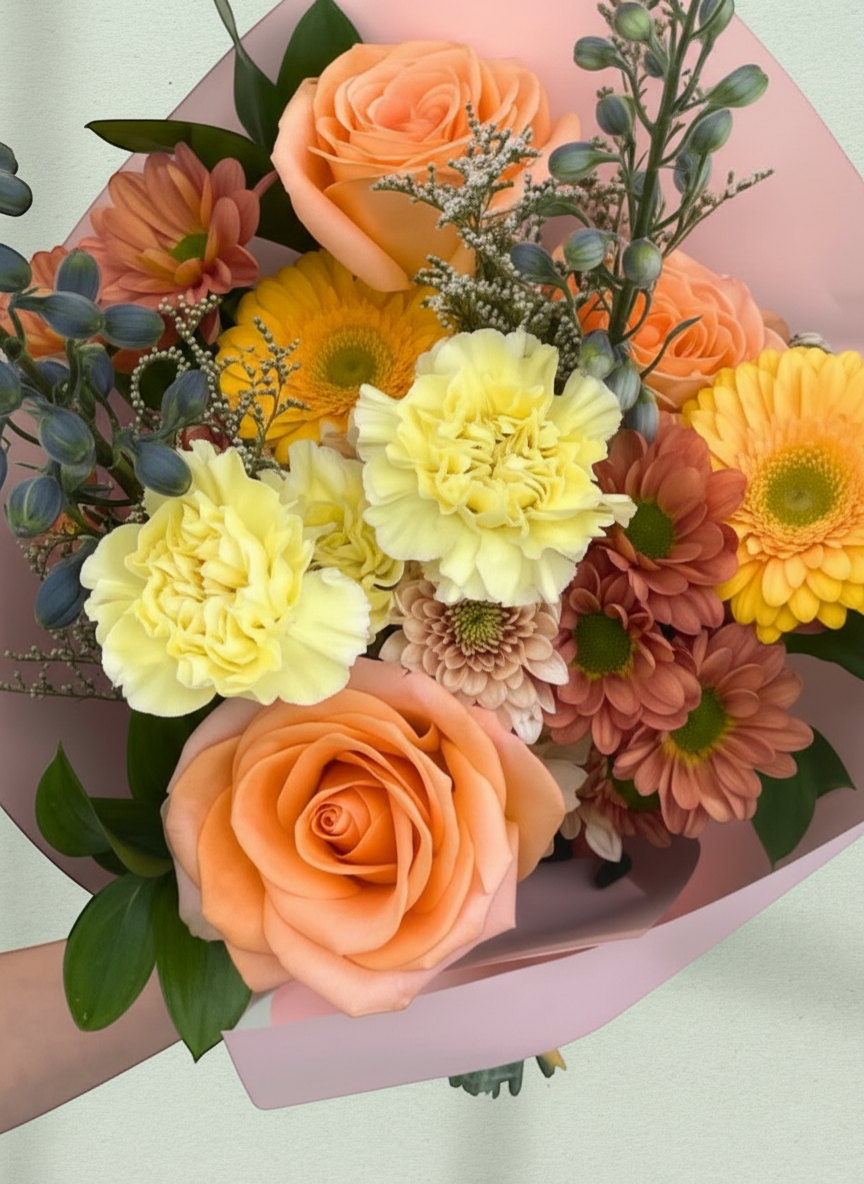 Lakewood Florist bouquet with orange roses, yellow carnations, gerbera daisies, and blue delphinium.